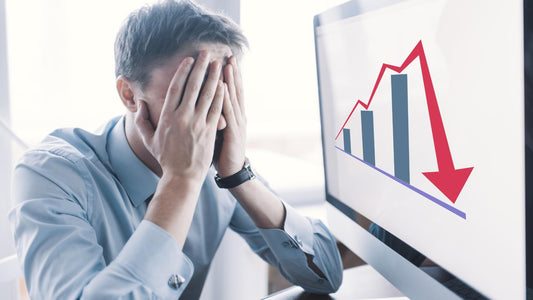 Frustrated business owner looking at a computer screen displaying a declining sales graph, symbolizing lost revenue from not going digital.